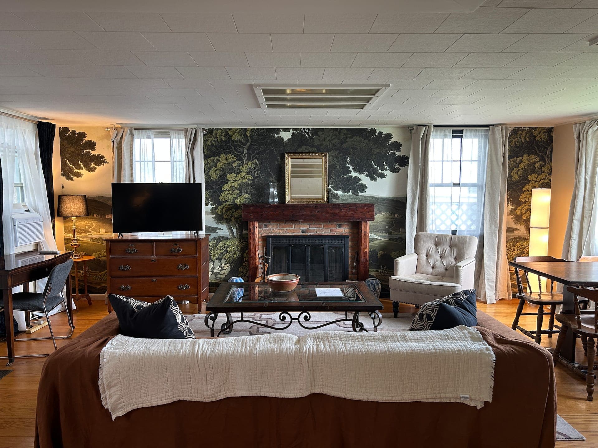 Meadow Suite living room with landscape mural wall and brick fireplace